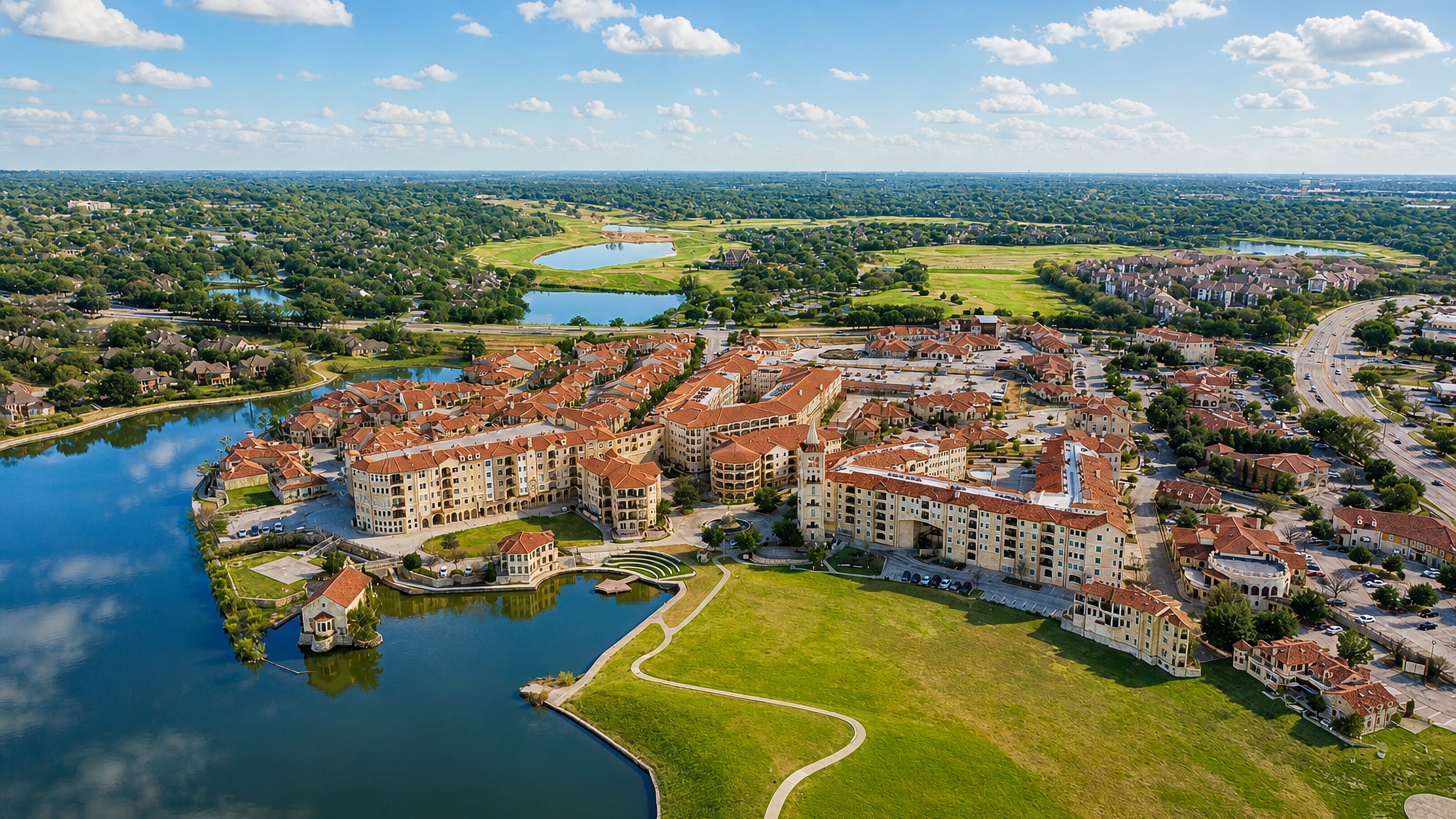 Aerial view of McKinney, Texas, showing a lakeside terracotta-roofed residential district beside golf-course greens.
