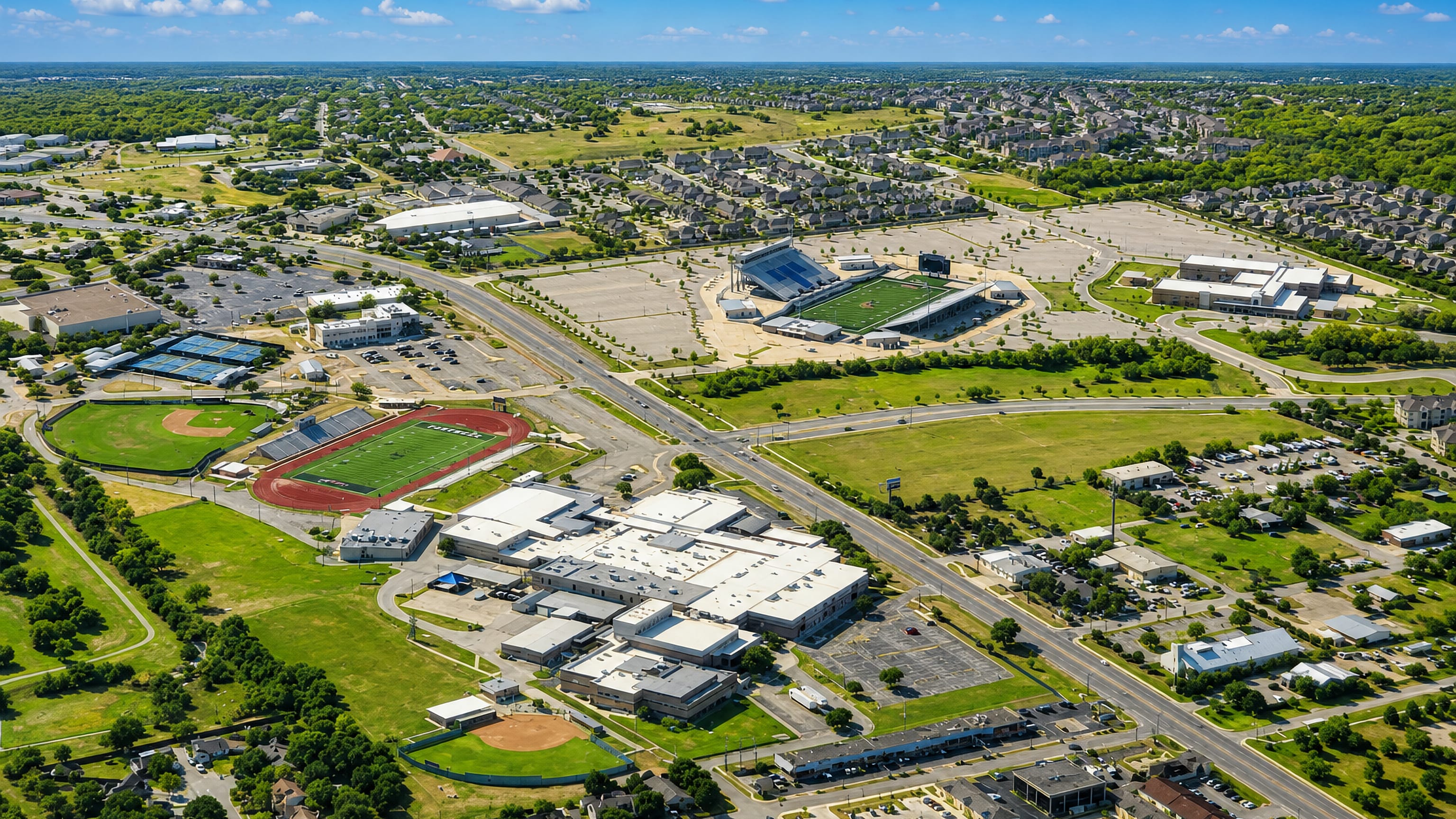 Aerial view of Pflugerville, Texas, showing its high school campus, football stadium and surrounding subdivisions.