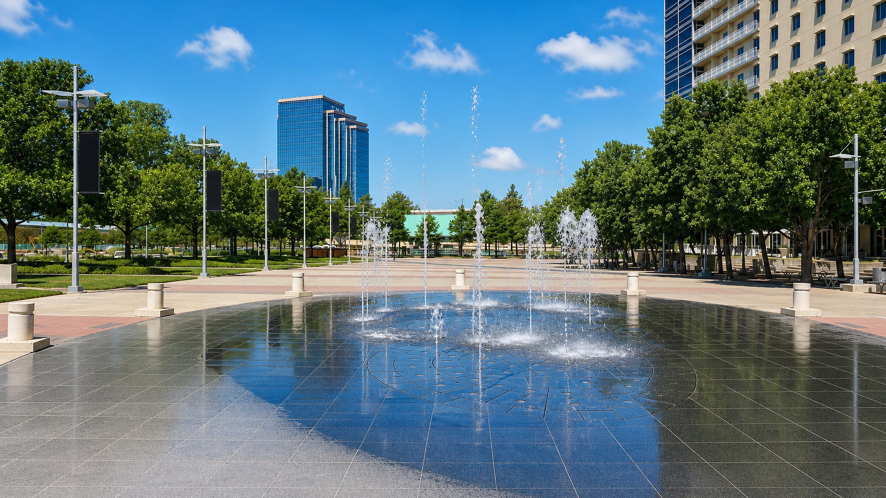 A splash fountain plaza backed by a blue-glass office tower in Richardson, Texas.