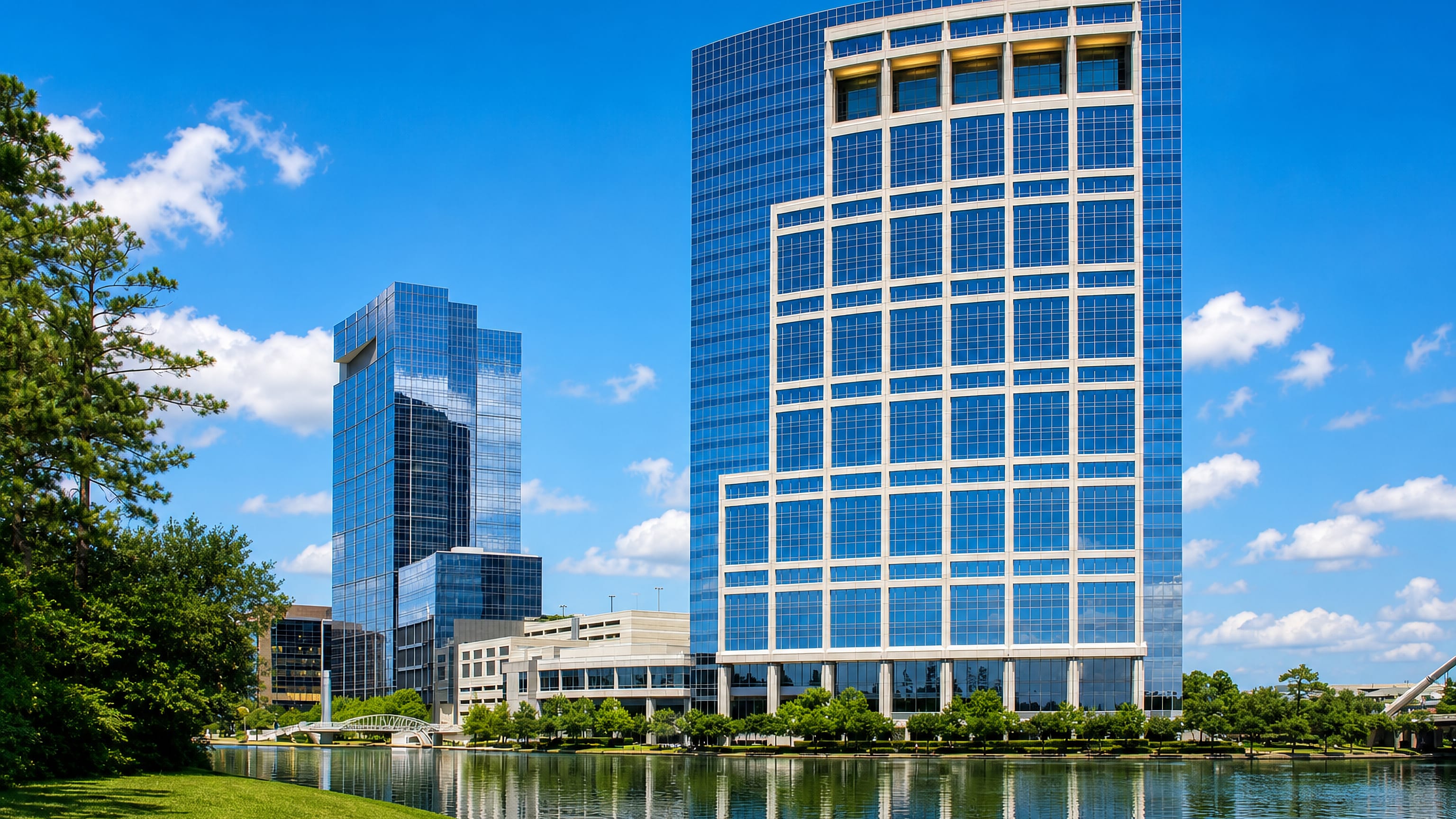 Glass office towers and a footbridge reflected in the waterway at The Woodlands, Texas.