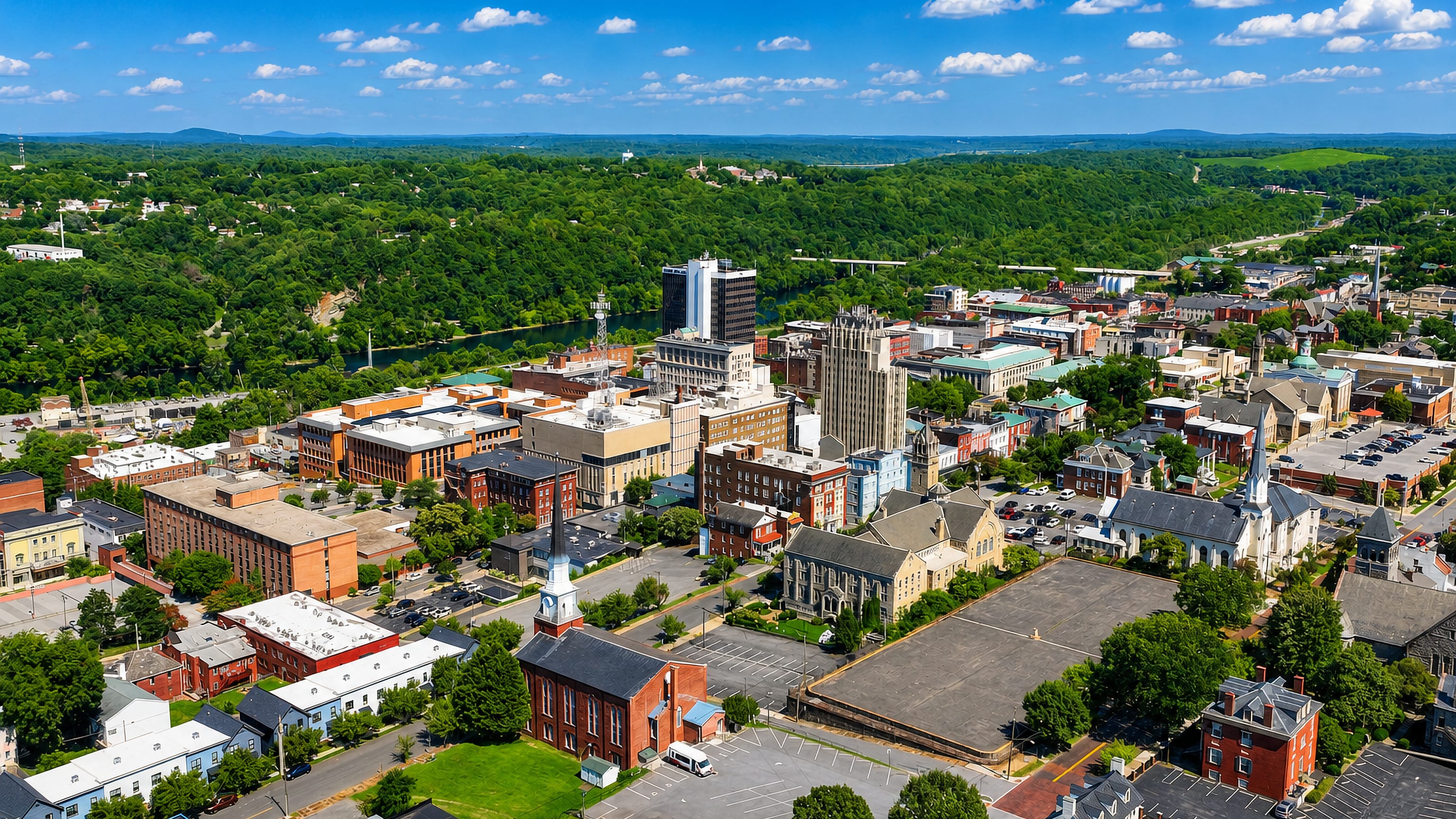 Aerial view of downtown Lynchburg, Virginia, its art deco tower and church spires above the James River.