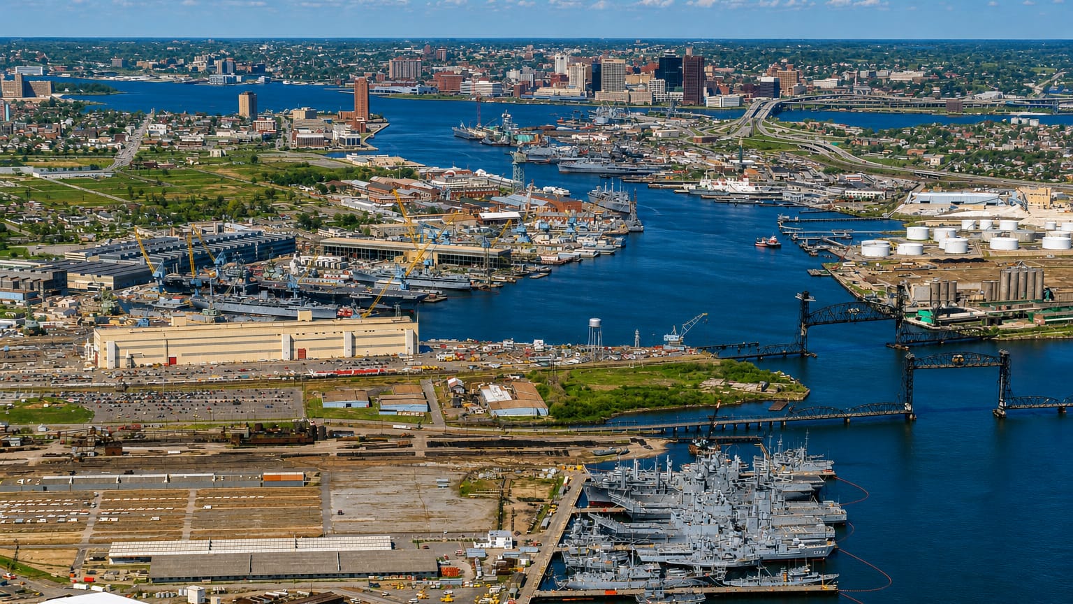 Aerial view of Norfolk, Virginia, with its naval shipyard, warships and downtown skyline across the harbor.