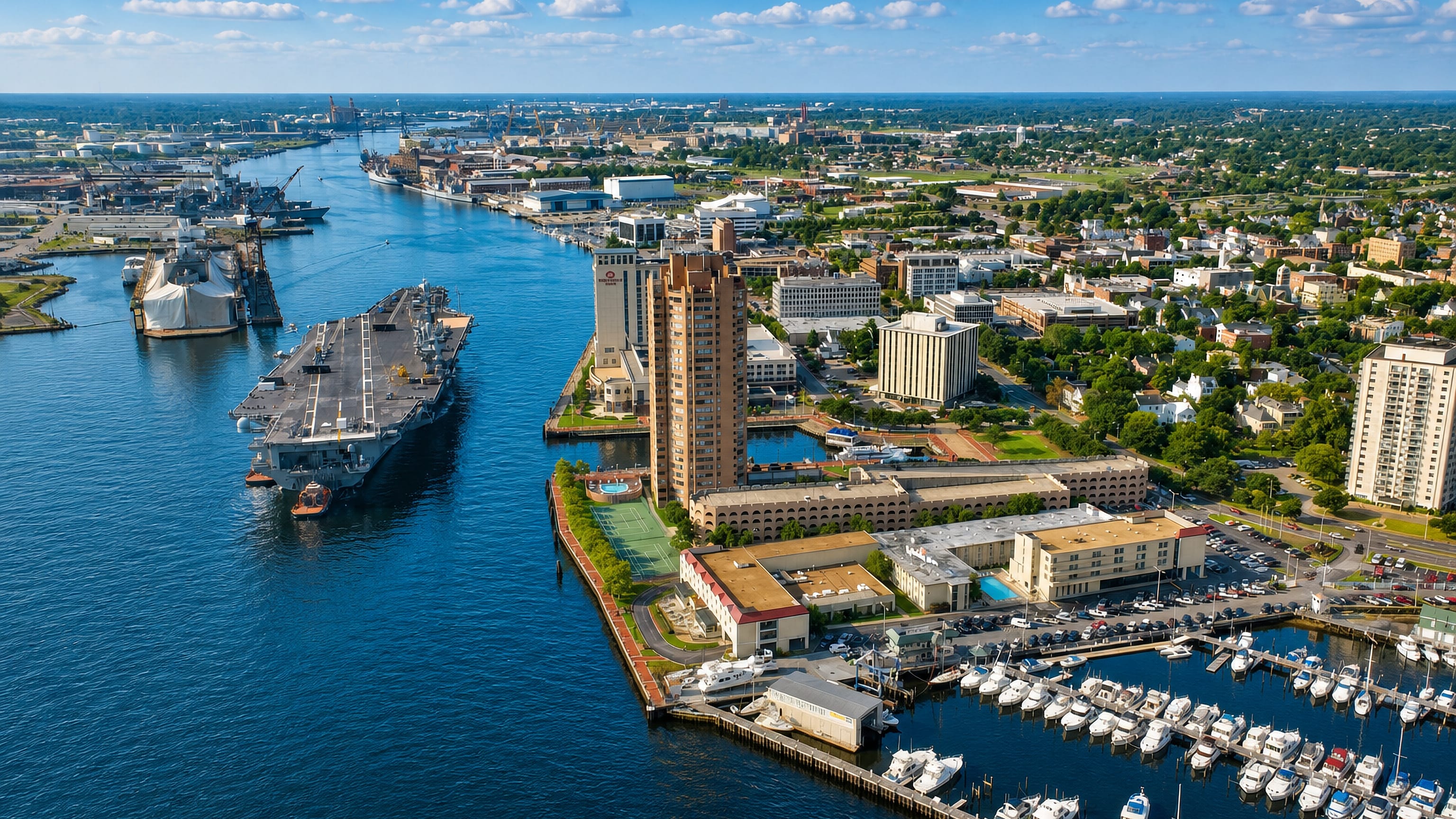 Aerial view of Portsmouth, Virginia's Elizabeth River waterfront, marina and naval ships across the channel.
