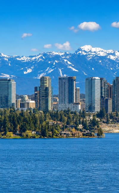 Bellevue, Washington skyline on the shore of Lake Washington backed by the snow-capped Cascade Mountains.