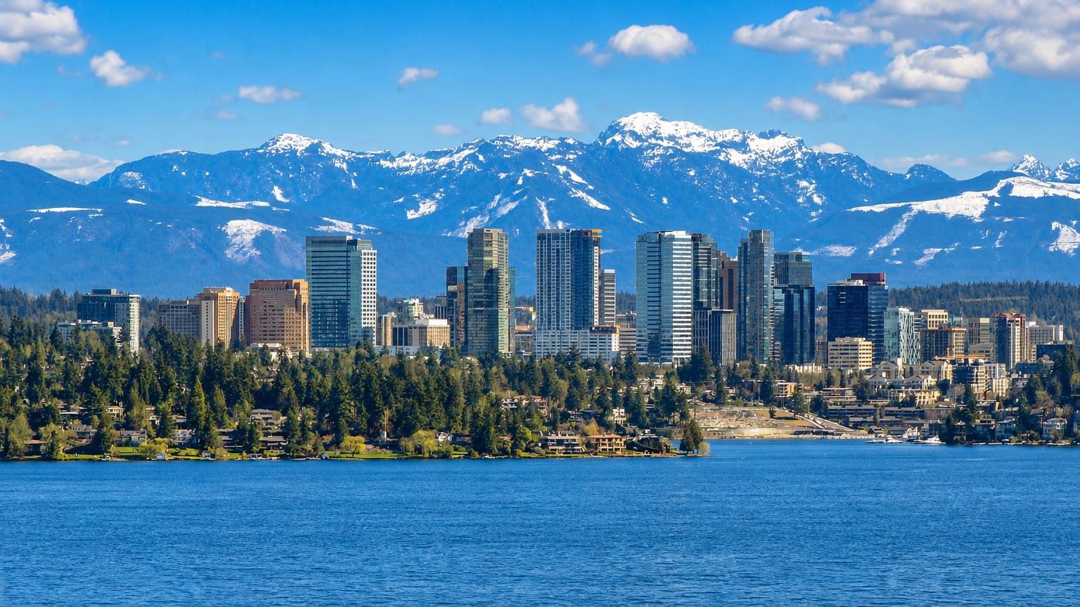 Bellevue, Washington skyline on the shore of Lake Washington backed by the snow-capped Cascade Mountains.
