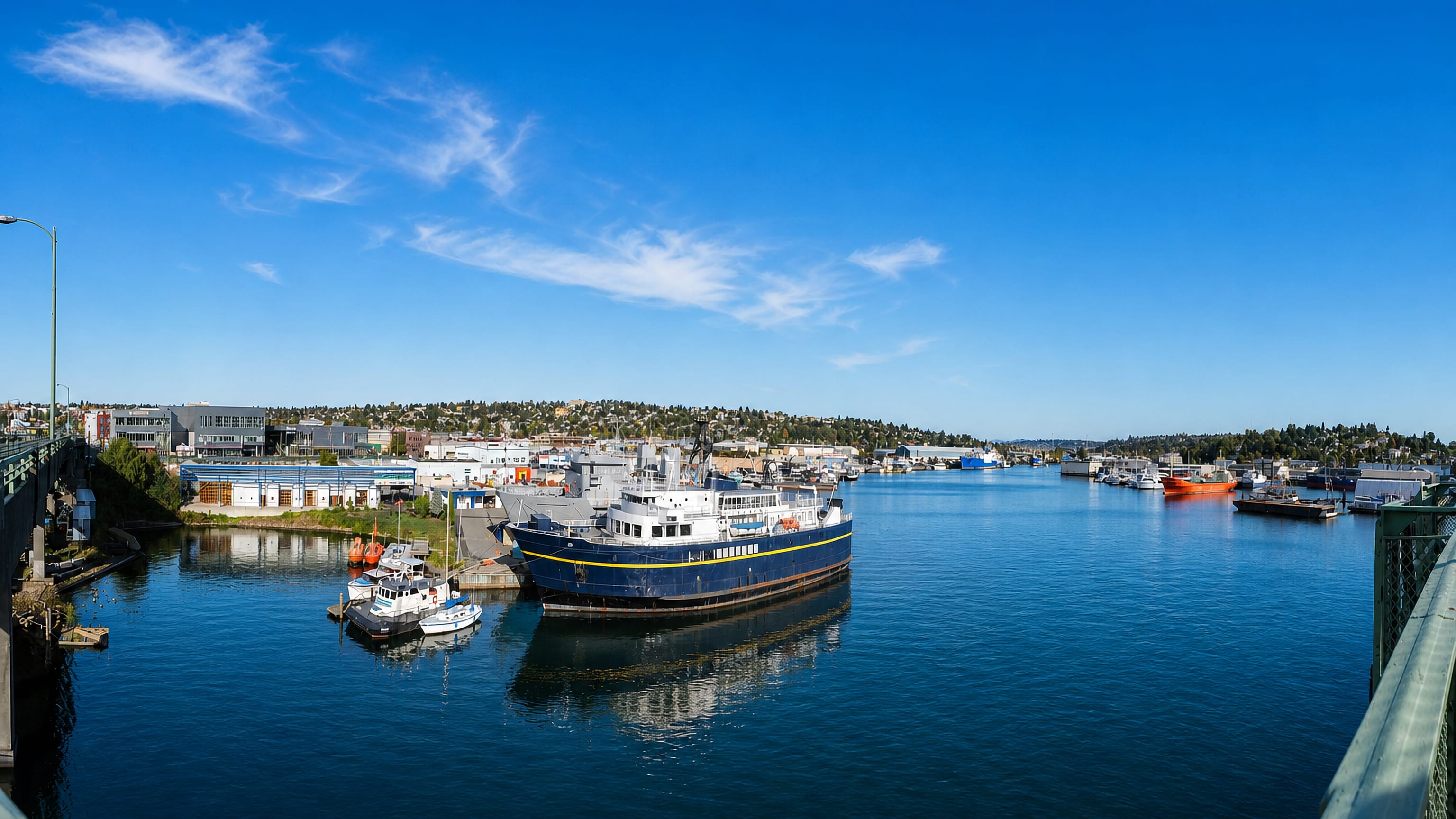 Fishing vessels moored along Salmon Bay in Ballard, Seattle, framed by the Ballard Bridge.