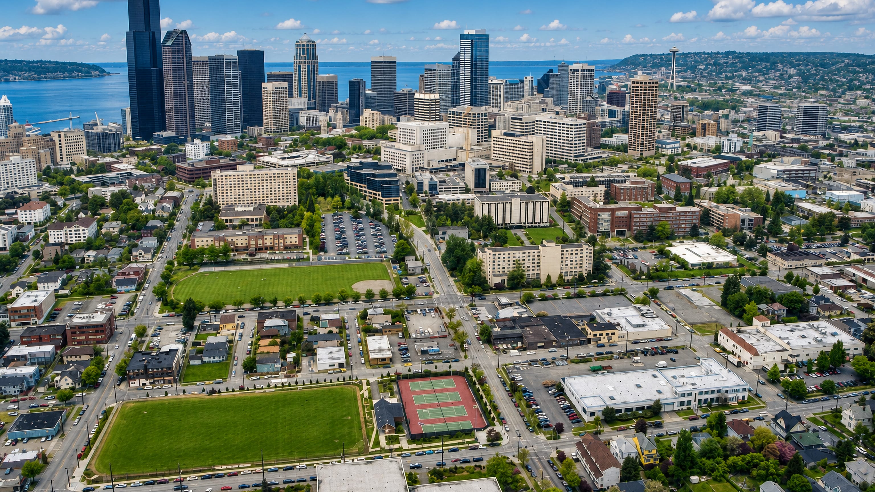 Aerial view over Seattle's Central District toward the downtown skyline, Space Needle and Elliott Bay.