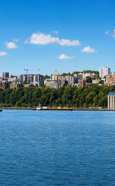 Tacoma, Washington waterfront across Commencement Bay, with a hillside of buildings and a grain terminal.