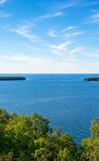 Wooded islands in the blue waters of Green Bay seen through foreground trees, Wisconsin.