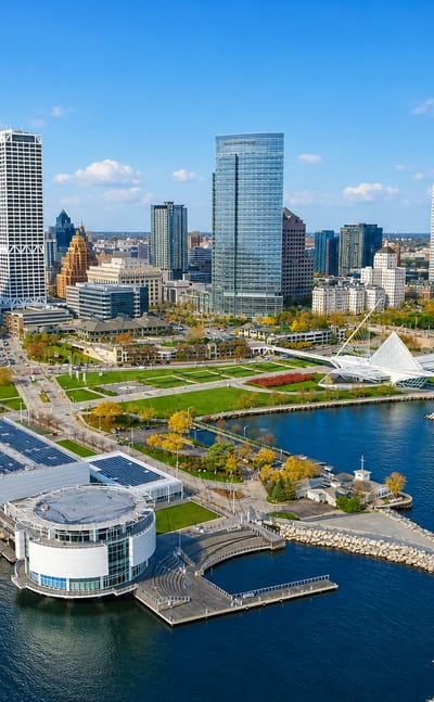 Aerial view of the Milwaukee lakefront with the white Milwaukee Art Museum pavilion and downtown skyline.