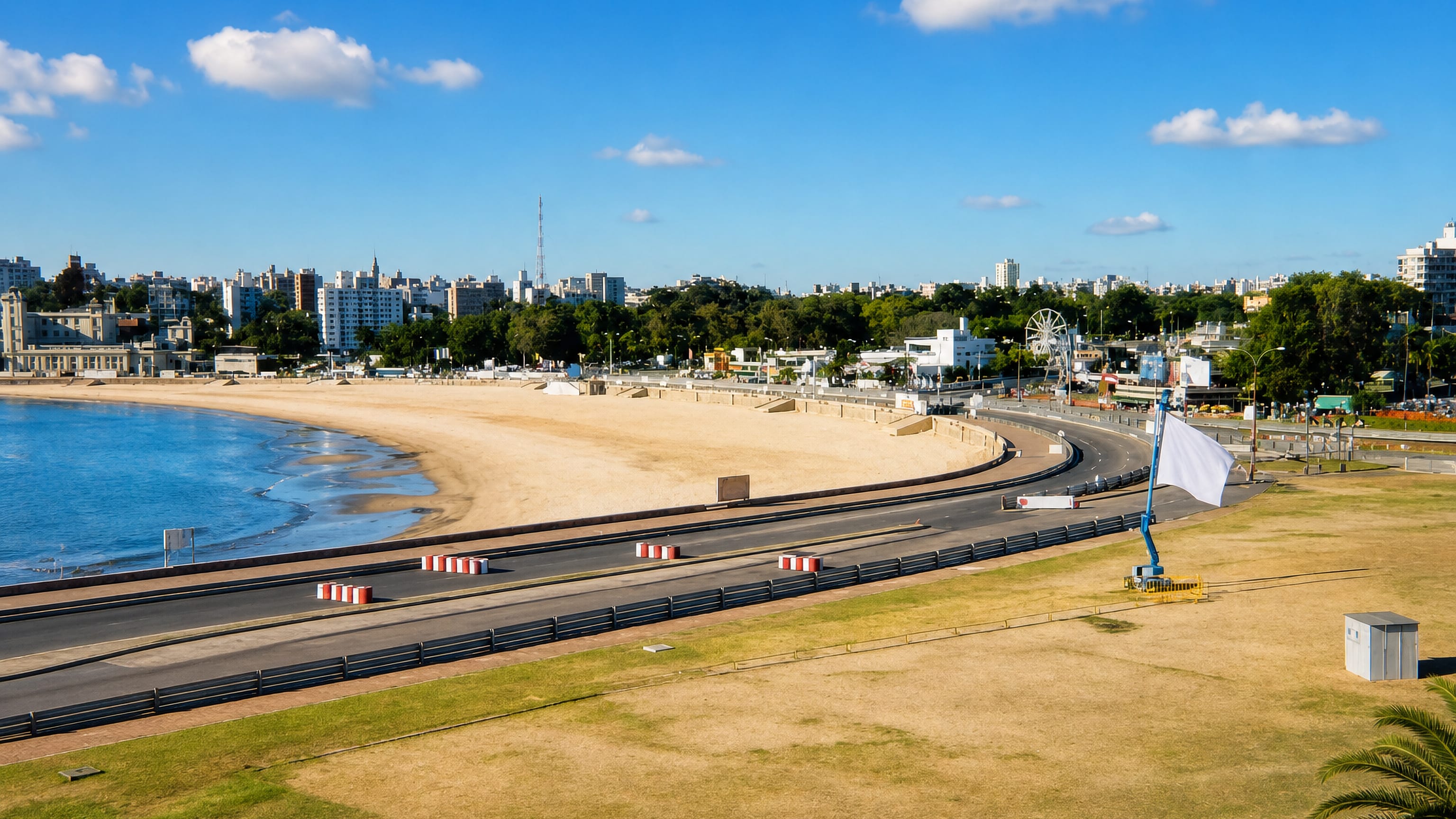 Curving rambla and sandy beach with a ferris wheel and the city skyline at Parque Rodó, Montevideo.