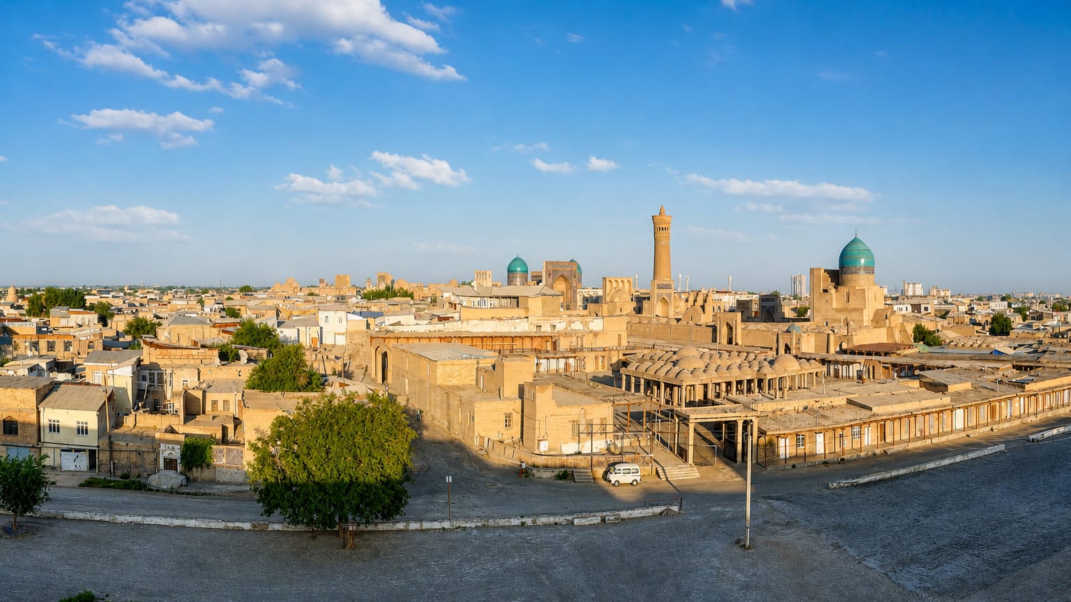 Bukhara's old town with the Kalyan Minaret and turquoise-domed mosques rising above sand-coloured houses