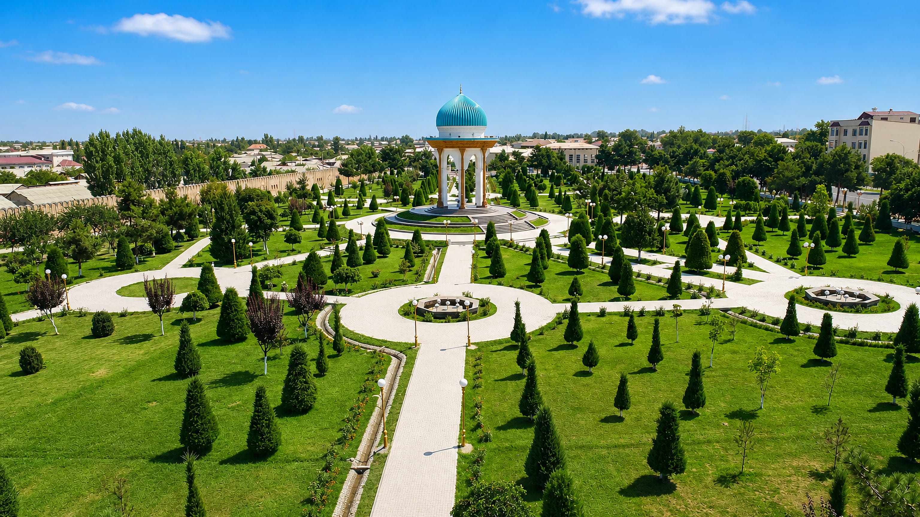 Turquoise-domed rotunda at the centre of a formal park with clipped conifers in Marg'ilon, Uzbekistan.