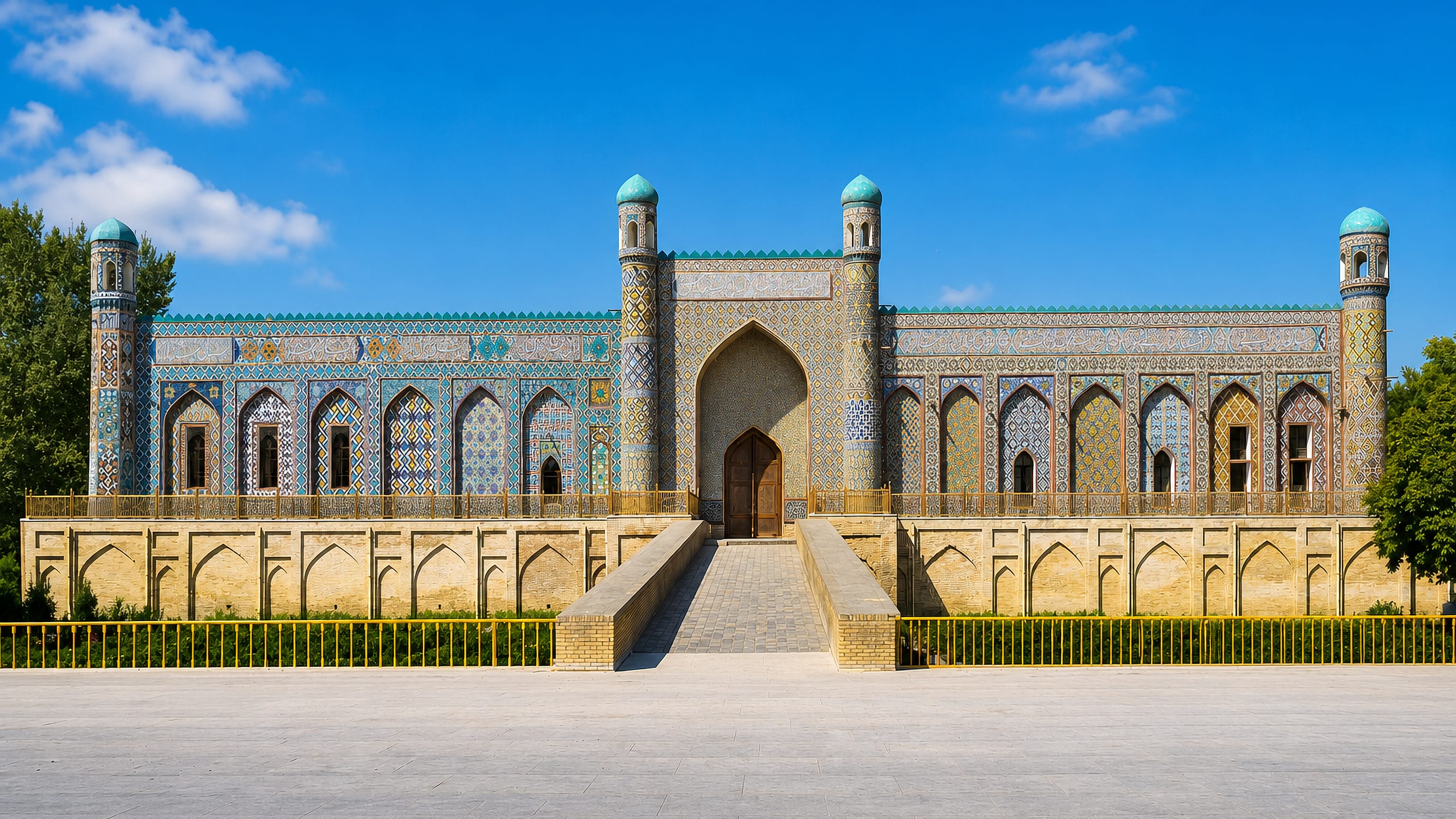 The tiled facade and turquoise minarets of the Khudayar Khan Palace in Qo'qon, Uzbekistan.