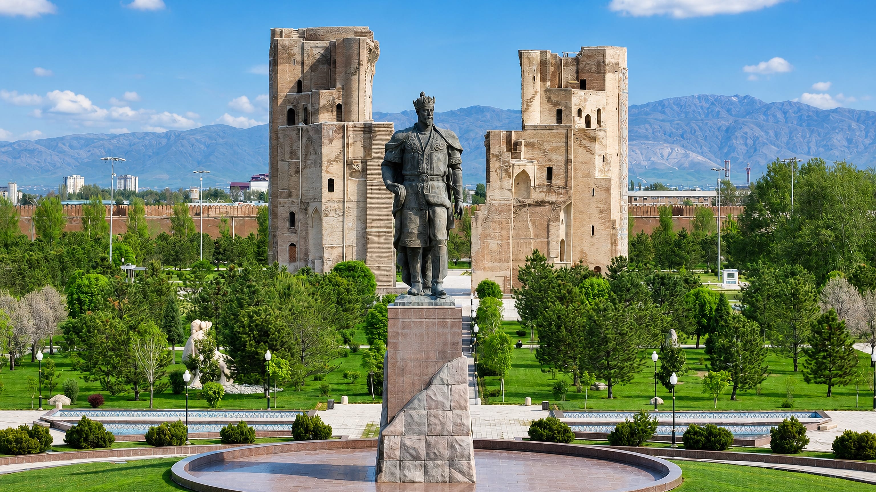 The Amir Timur statue stands before the towering Ak-Saray palace ruins in Shahrisabz, Uzbekistan.