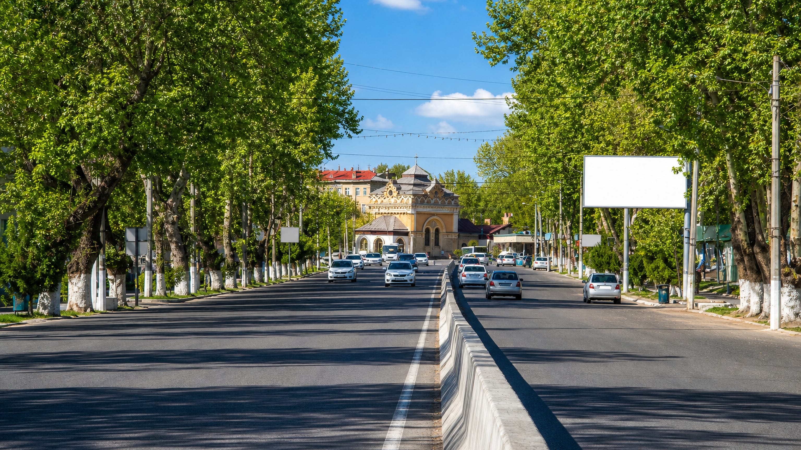 Tree-lined divided boulevard leading to an ornate yellow building in Chirchiq, Uzbekistan