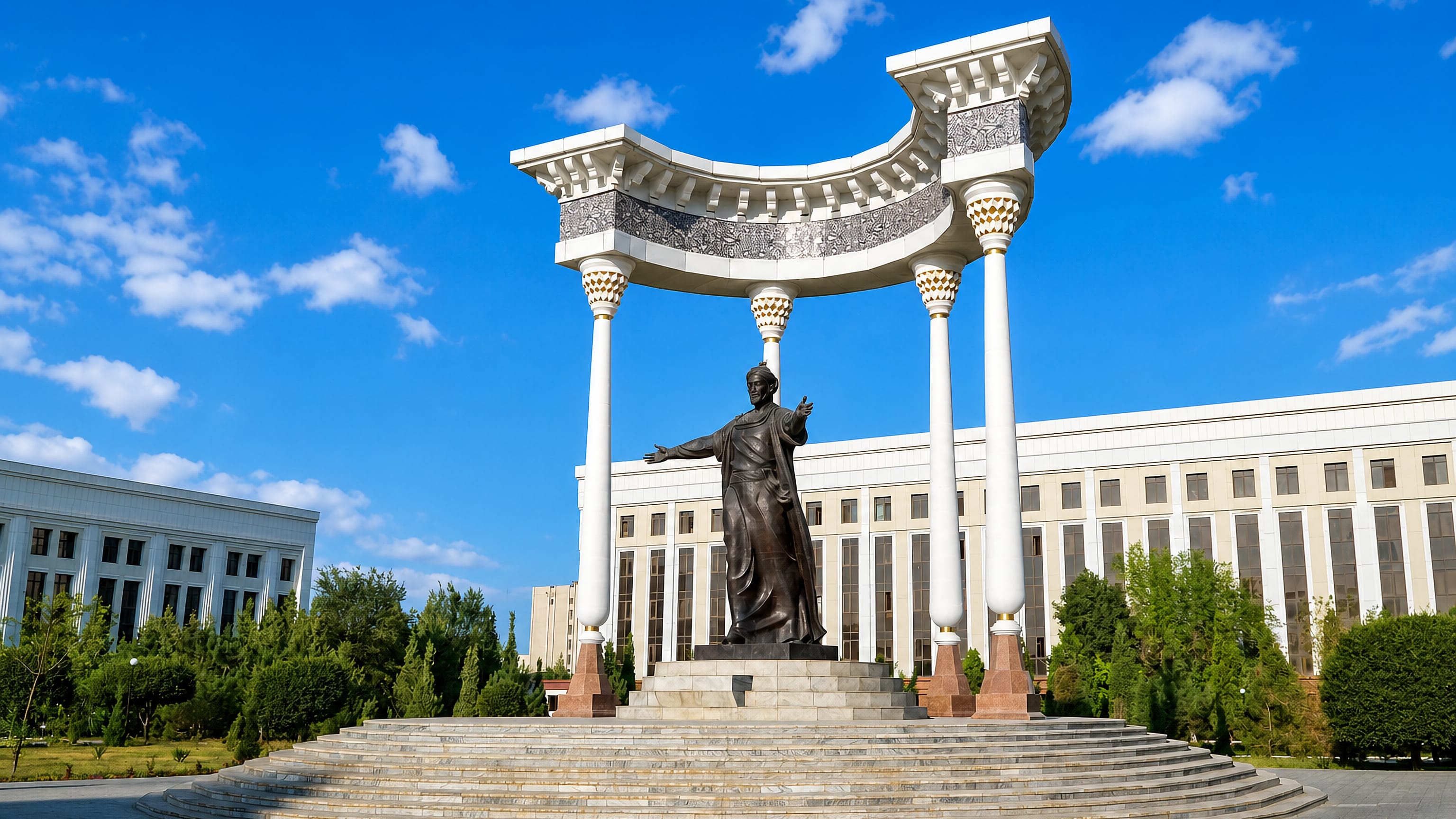 The al-Khwarizmi statue beneath its white colonnade on a civic square in Urganch, Uzbekistan.