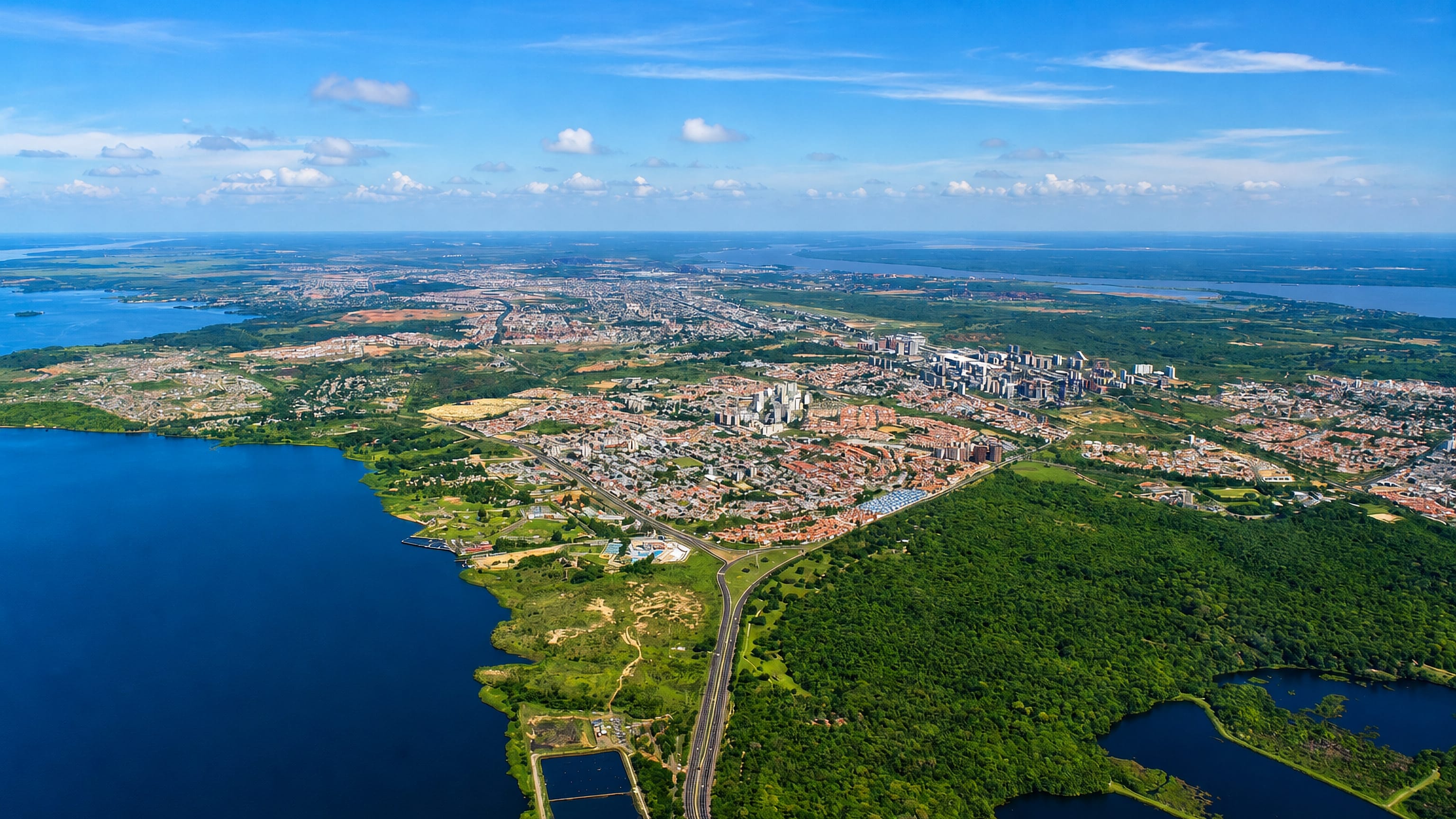 Aerial view of Ciudad Guayana spreading along the Orinoco riverbank between forest and open water.