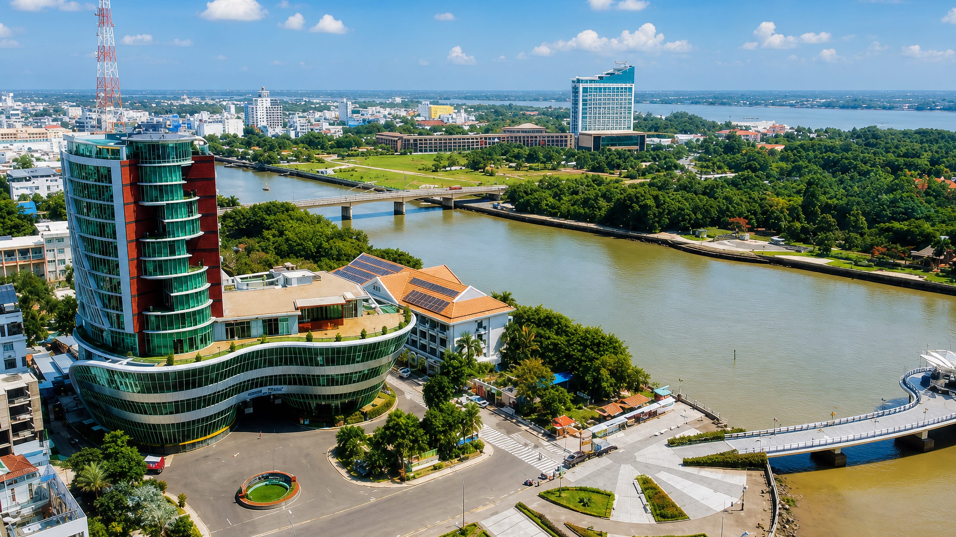 Aerial view of Cần Thơ's riverfront in Vietnam, with a curved glass tower, canal bridges and the Hậu River
