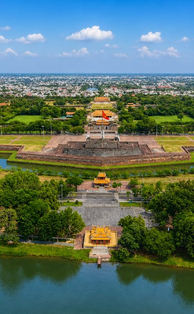 Aerial view of Hue's Imperial Citadel with its flag tower and moat beside the Perfume River.