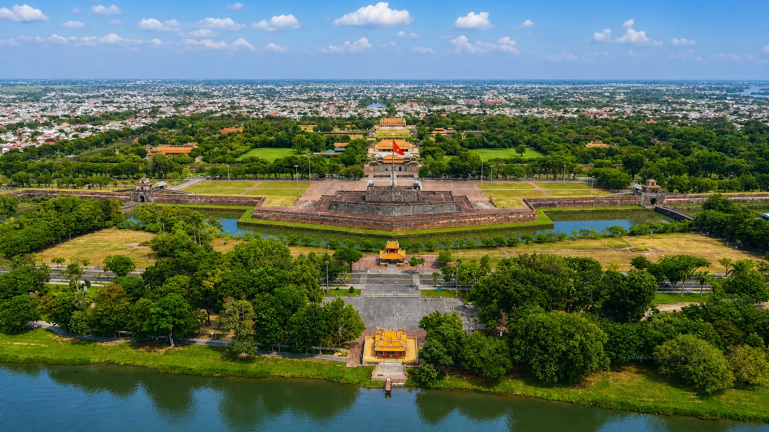 Aerial view of Hue's Imperial Citadel with its flag tower and moat beside the Perfume River.