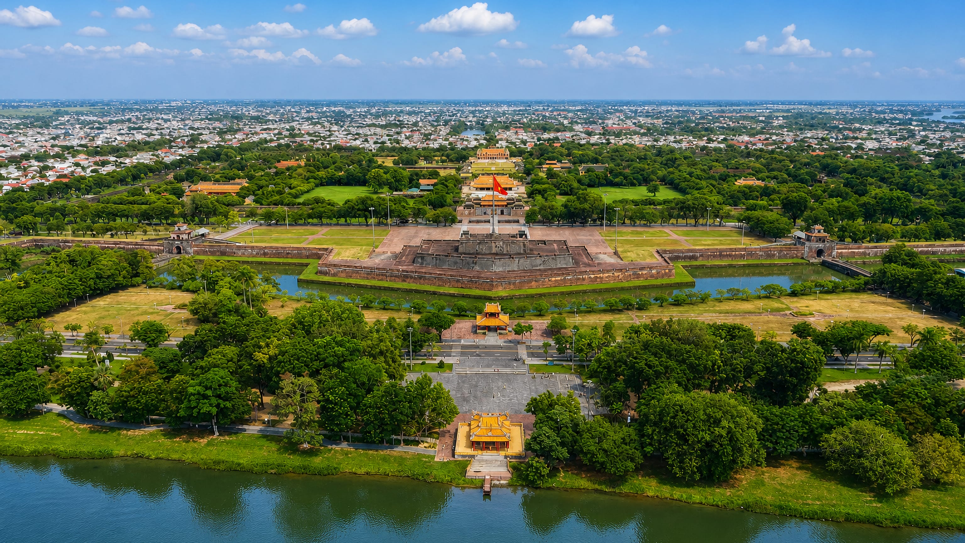 Aerial view of Hue's Imperial Citadel with its flag tower and moat beside the Perfume River.