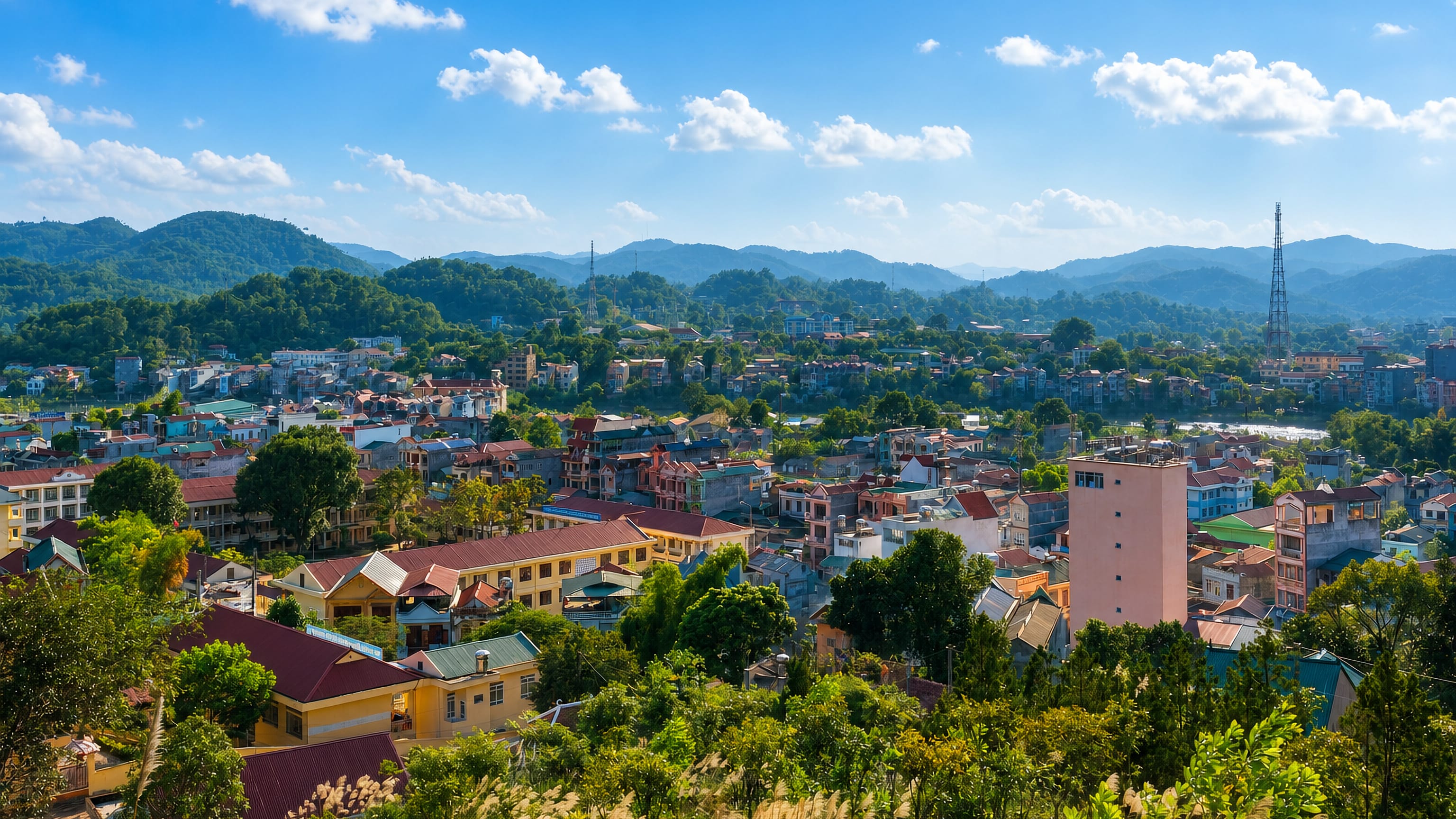 Colourful low-rise rooftops of Cao Bằng filling a valley ringed by forested hills