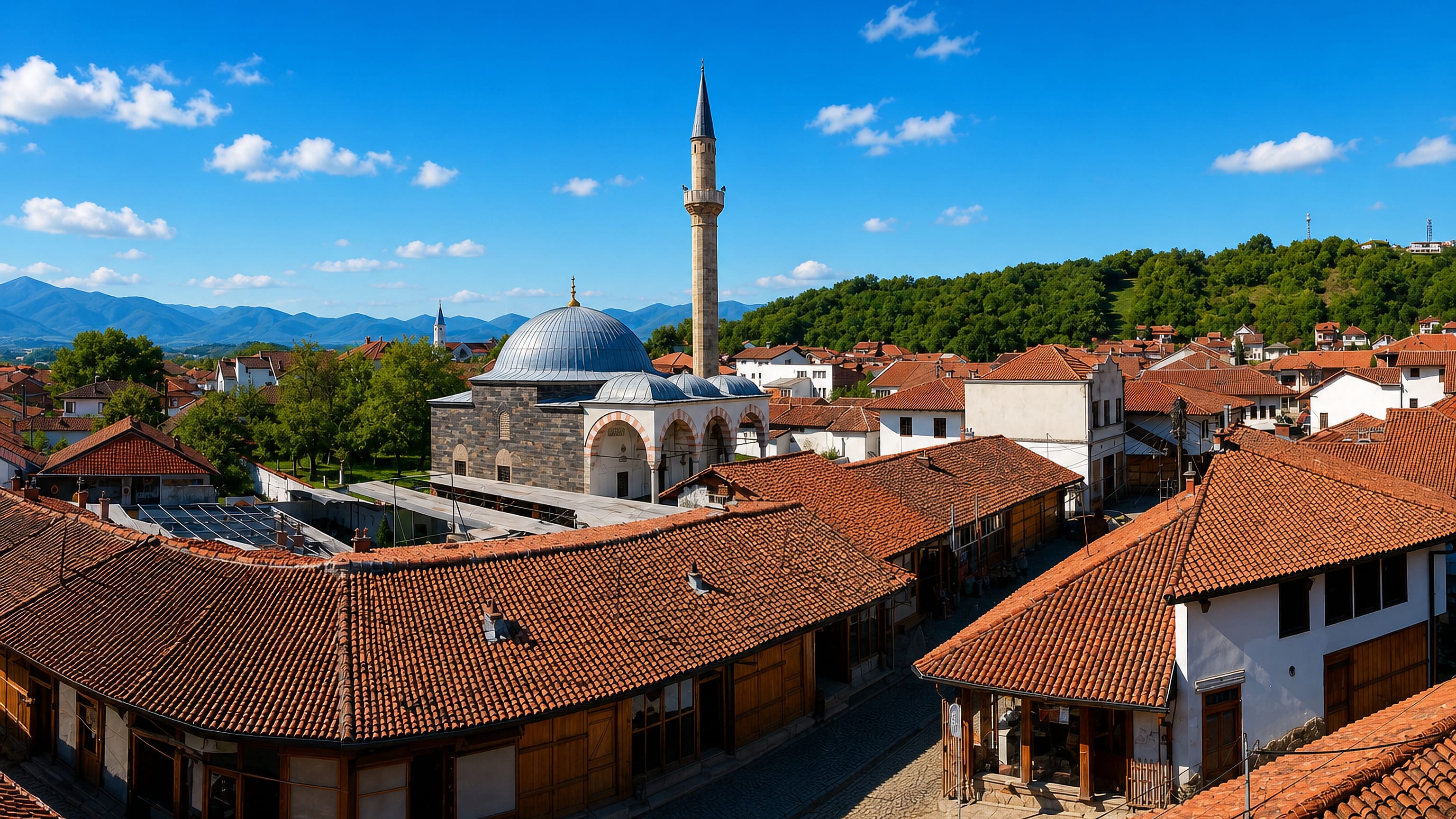 Tiled roofs of Gjakova's Grand Bazaar around the Hadum Mosque and its minaret, western Kosovo.