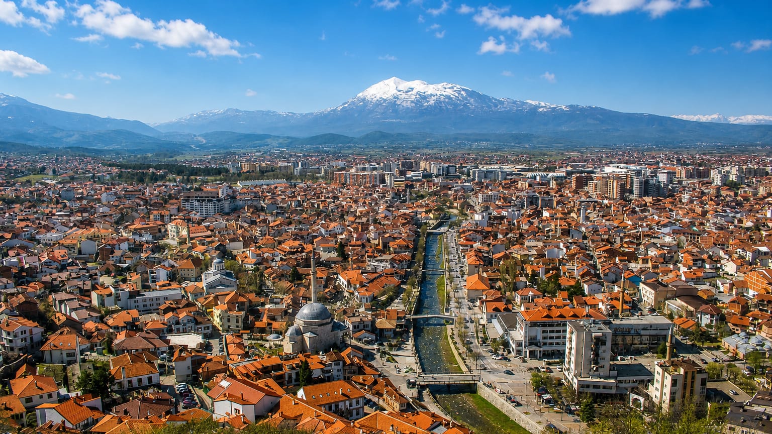 Prizren, Kosovo, red-roofed old town along the Bistrica River below the snow-capped Sharr Mountains.