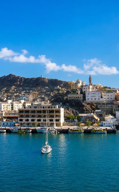 Whitewashed harbour town below rugged volcanic hills at the port of Aden, Yemen