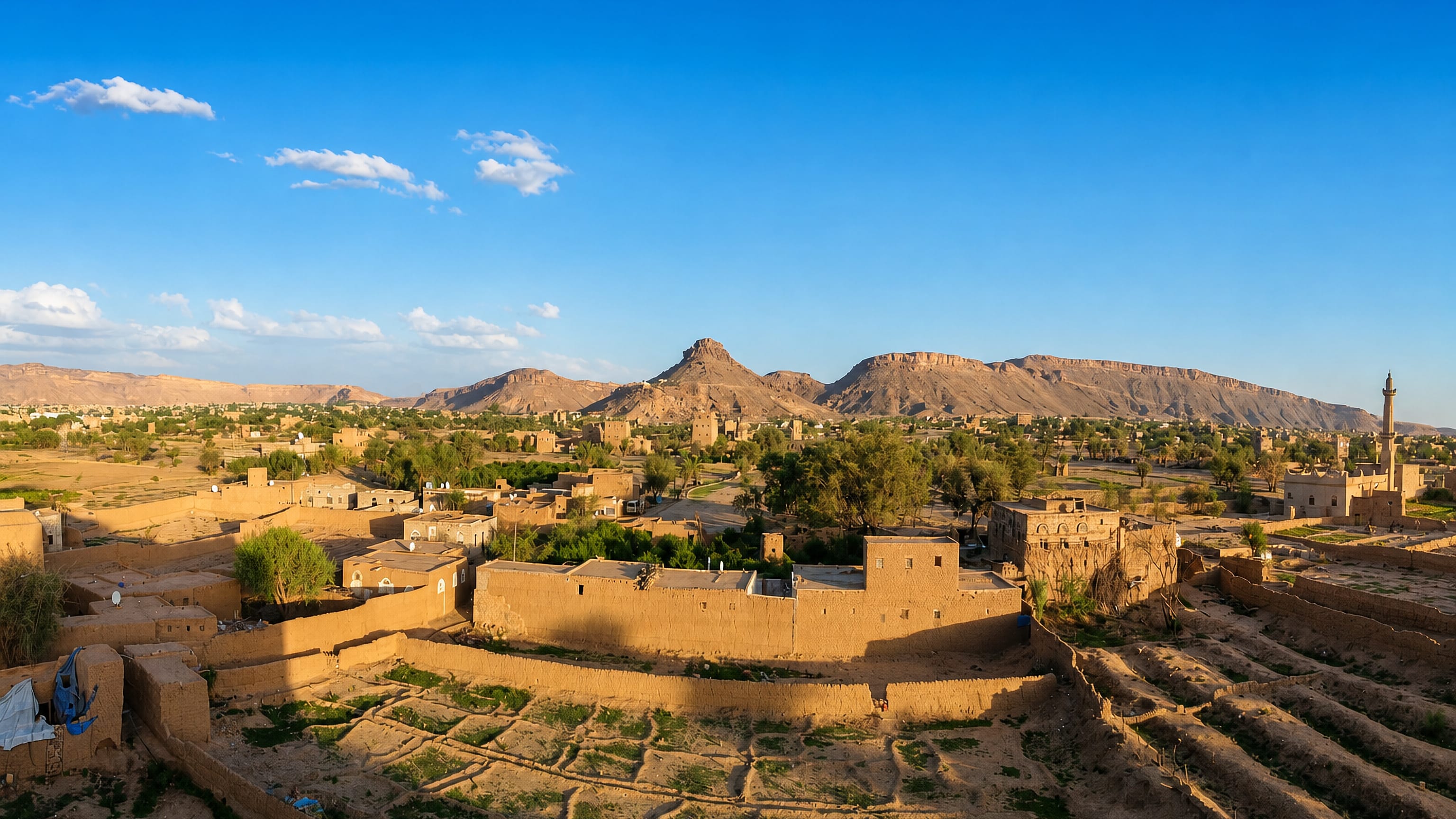 Mud-brick houses and walled gardens of Sa'dah, Yemen, below the arid escarpment ringing the old town