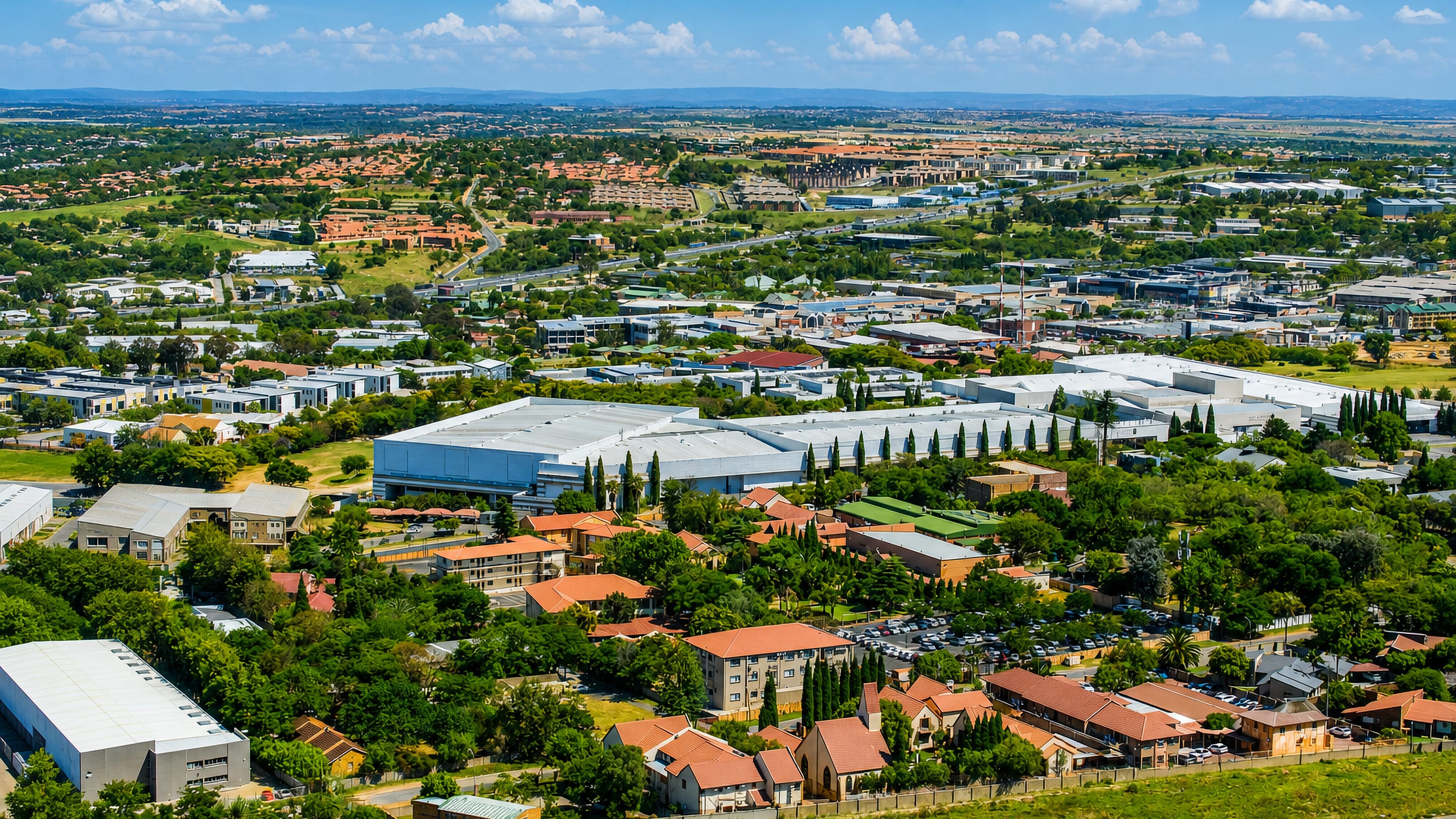 Aerial view over Midrand's business parks, warehouses and tiled-roof estates on the Gauteng highveld