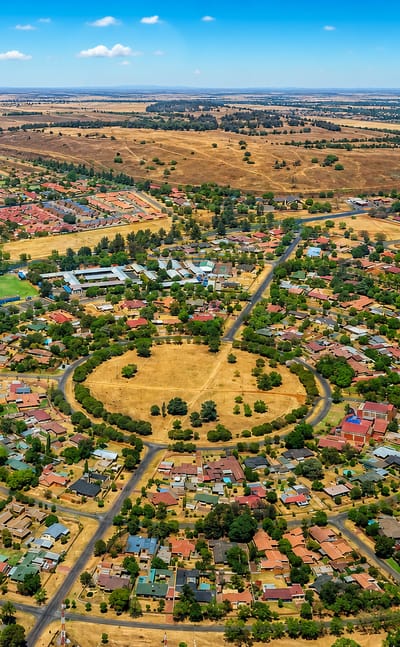 Aerial view of Springs, Gauteng, with a circular park ringed by suburban homes and open veld beyond