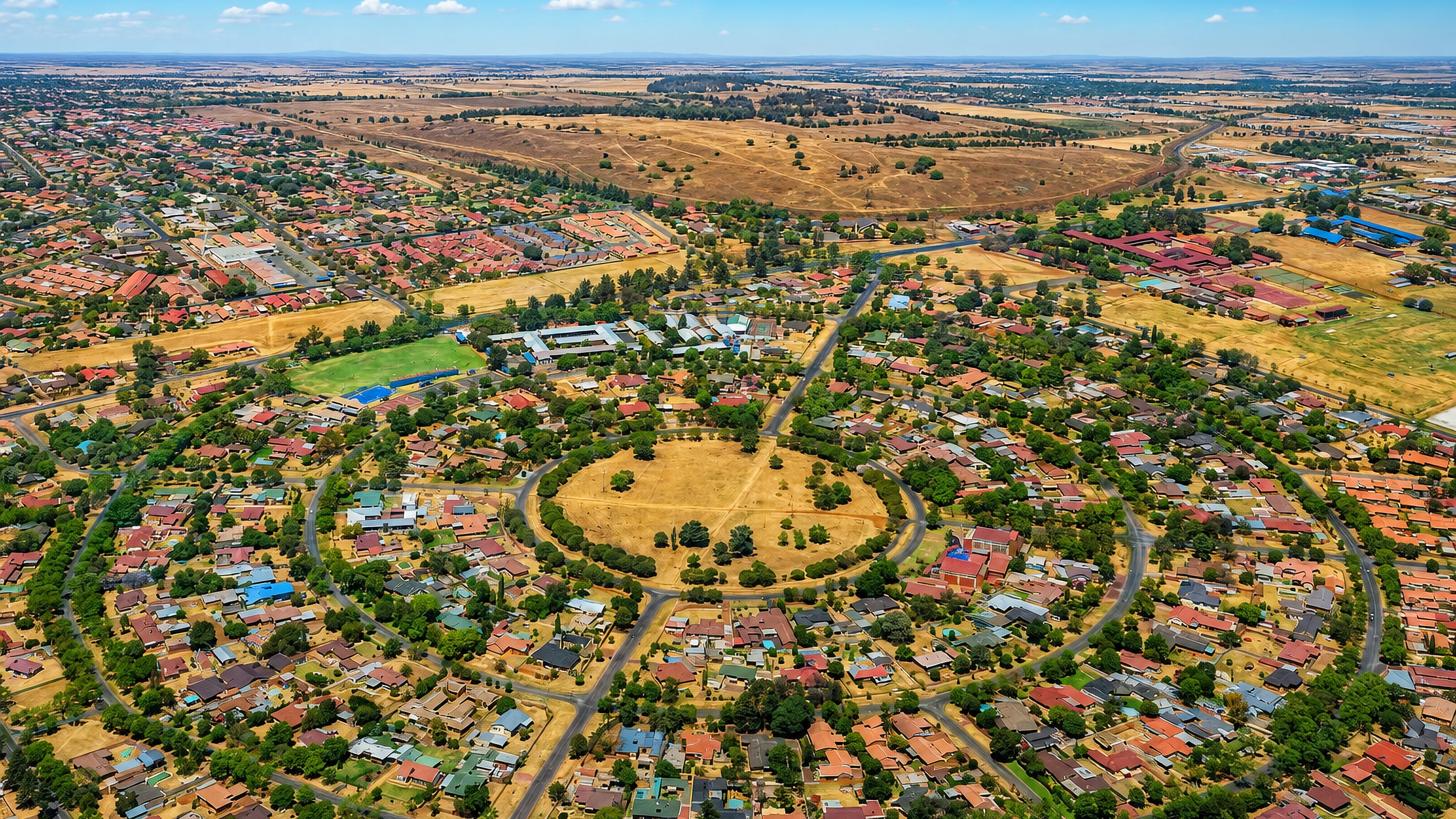 Aerial view of Springs, Gauteng, with a circular park ringed by suburban homes and open veld beyond