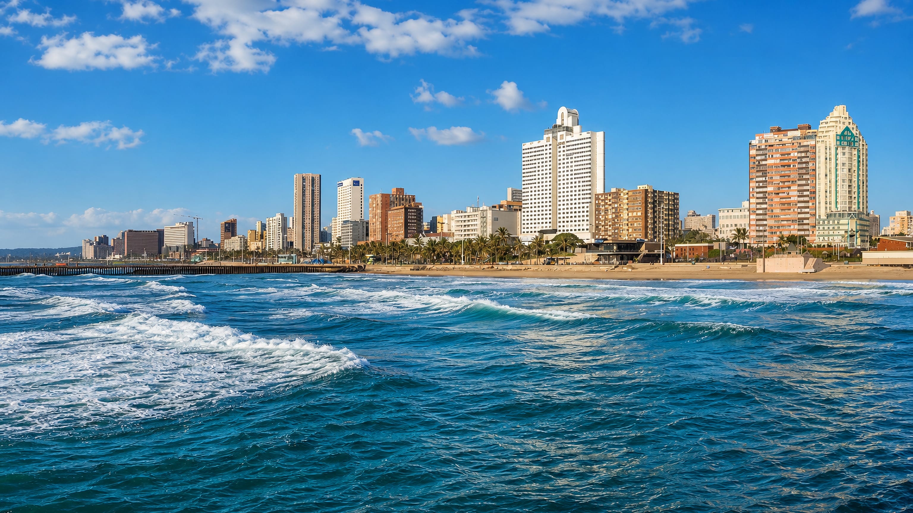 Durban's South Beach seen from the water, with surf, golden sand and the Golden Mile high-rise skyline.
